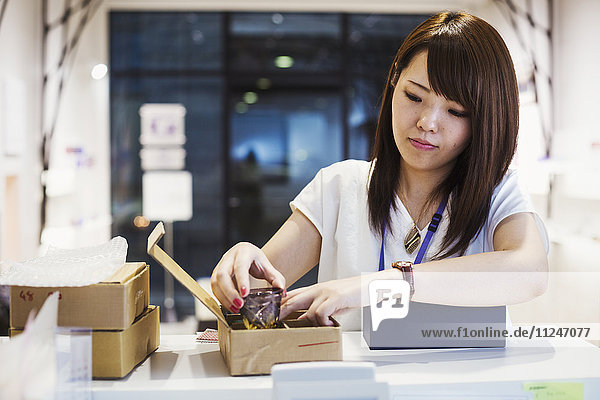 Saleswoman in a shop selling Edo Kiriko cut glass in Tokyo Japan.