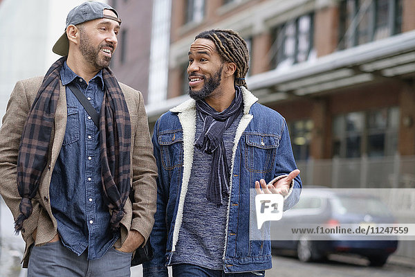 Lächelndes homosexuelles Paar auf der Straße
