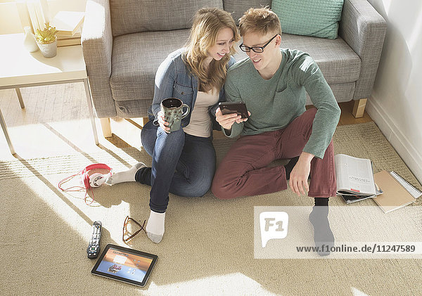 Junges Paar sieht sich einen Film auf einem digitalen Tablet an