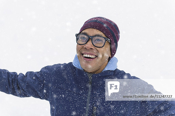Mittlerer erwachsener Mann auf Schnee stehend