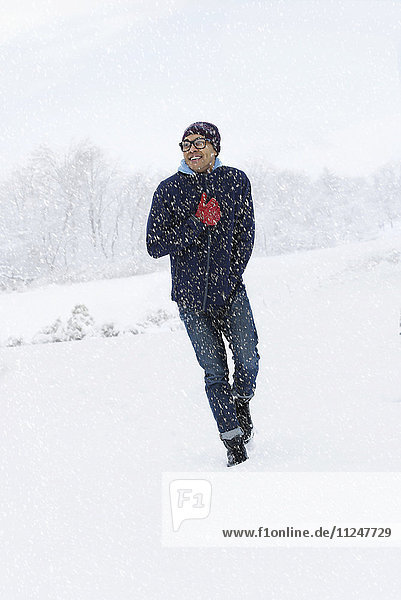 Mid adult man walking on snow