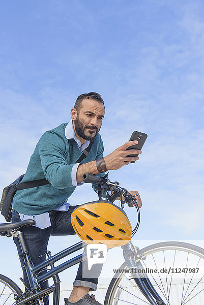Man with bike using phone