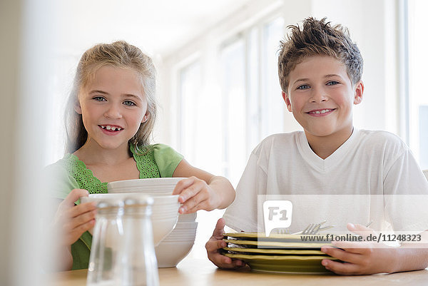 Bruder und Schwester (6-7  8-9) decken den Tisch