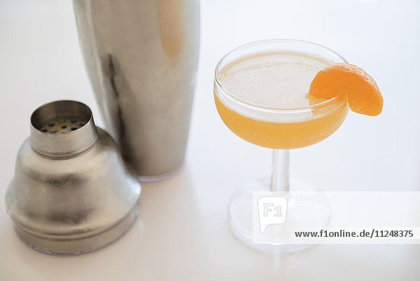 Cocktail im Trinkglas und Cocktailshaker auf dem Tisch