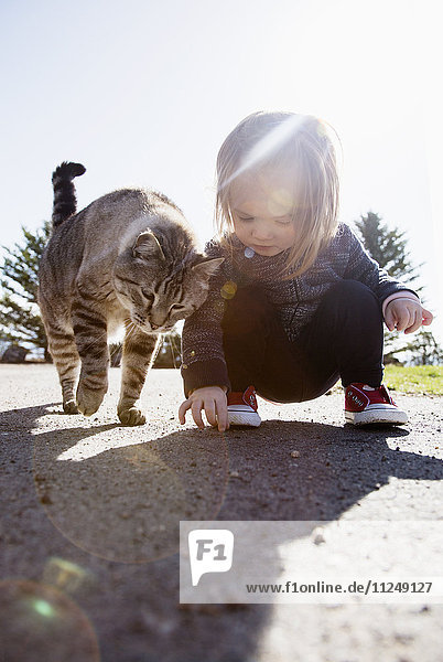 Kauerndes Mädchen (2-3) und Katze