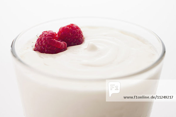 Yogurt with raspberries in drinking glass