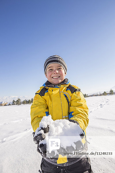 Porträt eines Jungen (8-9) mit Schnee in der Hand