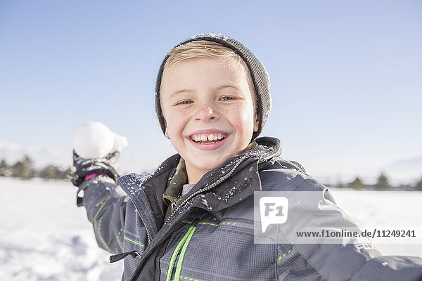Portrait of boy (8-9) throwing snowball
