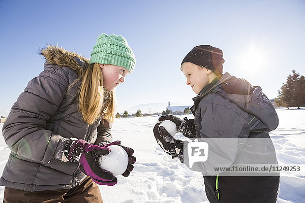 Children (8-9 10-11) playing with snowballs