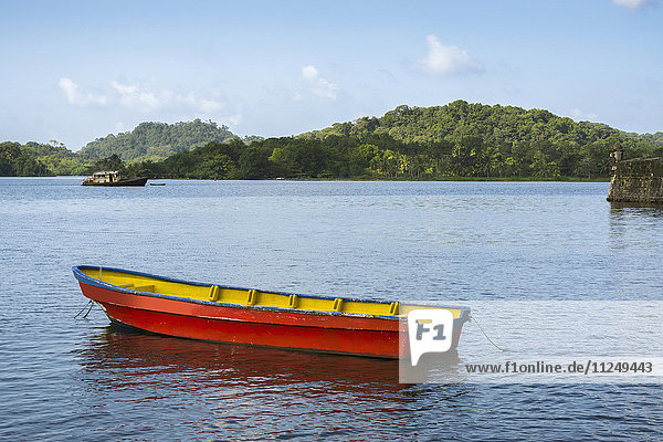 Boot auf Bucht mit grünen Hügeln im Hintergrund