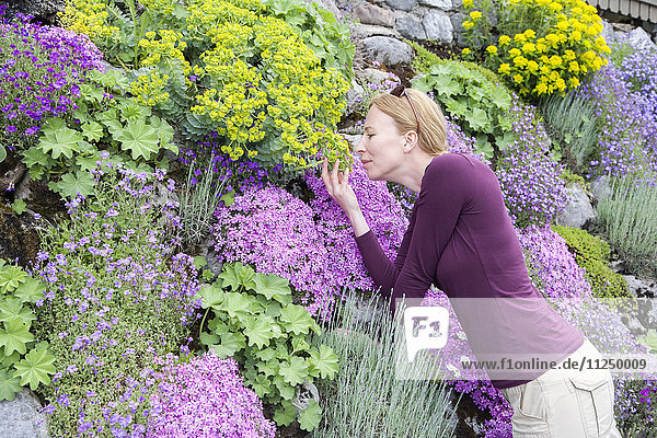 Frau riecht an Blumen
