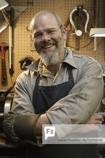Porträt eines lächelnden Juweliers in einer Werkstatt