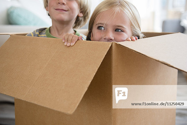 Junge (4-5) und Mädchen (6-7) sitzen in einer Box
