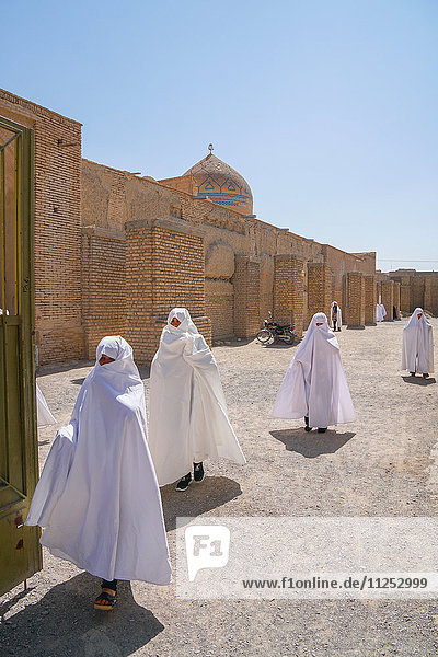 Frauen in weißen Tschadors verlassen die Jameh-Moschee  Varzaneh  Iran  Naher Osten