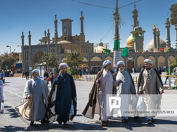Chatting mullahs against the minarets of the Hazrat-e Masumeh (Holy Shrine)  Qom  Iran  Middle East
