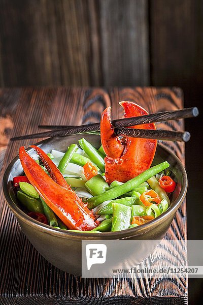 Nudeln mit Gemüse  Hummer und Essstäbchen (Asien)