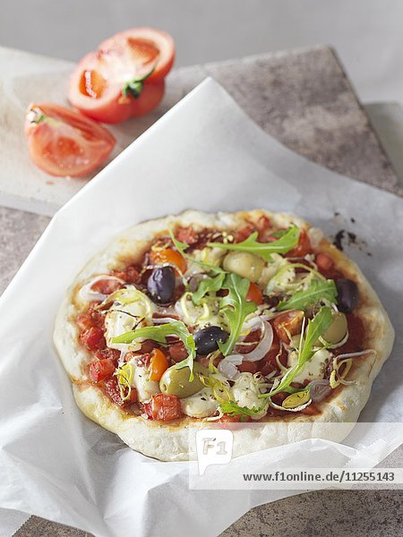 Pizza mit Oliven und Rucola