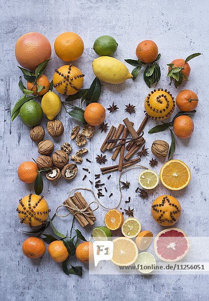 Verschiedene Zitrusfrüchte mit Nüssen und Gewürzen