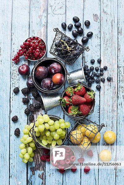 Stillleben mit verschiedenen Früchtesorten in Metallbehältern