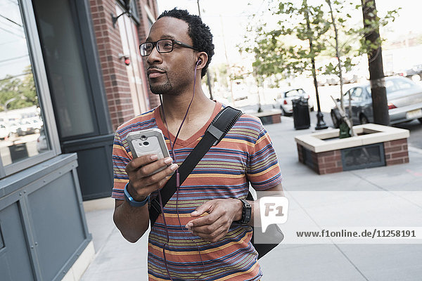 Mittlerer Erwachsener Mann mit Telefon auf der Straße
