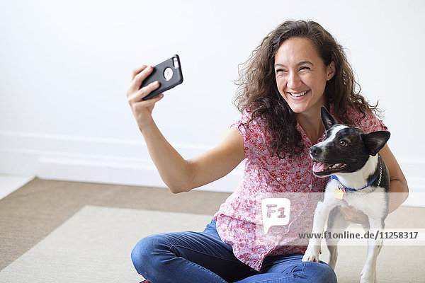 Young woman taking selfie with her dog