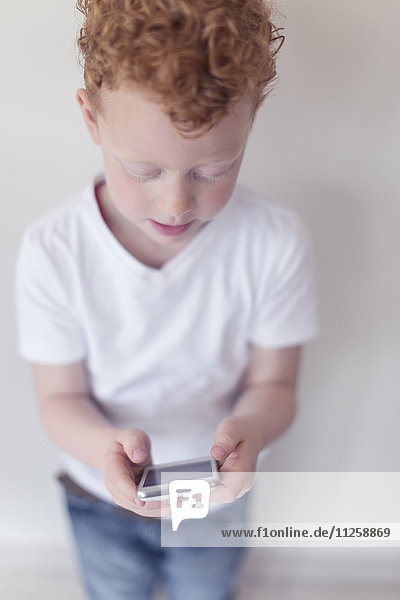 Boy (8-9) looking at smart phone