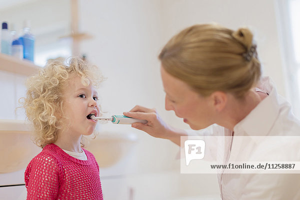 Mutter hilft Tochter (4-5) beim Zähneputzen