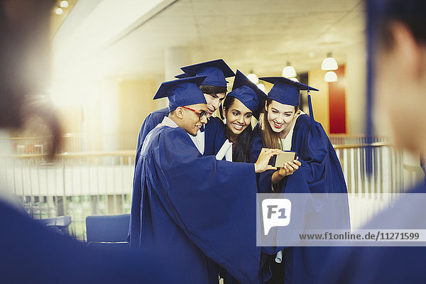 College graduates in cap and gown taking selfie