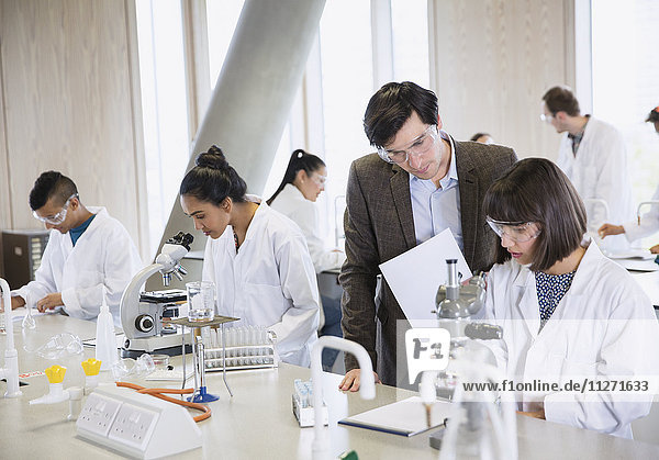 Wissenschaftsprofessor hilft Studenten bei der Durchführung wissenschaftlicher Experimente im Klassenzimmer des Wissenschaftslabors