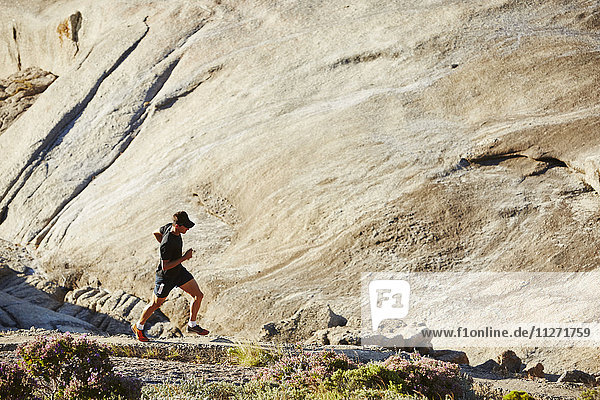 Triathleten-Läufer auf sonnigem Felsweg