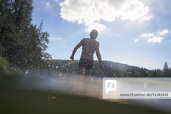 Mari man wading in lake