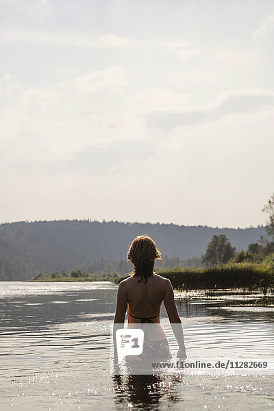 Kaukasische Frau im See stehend im Bikini
