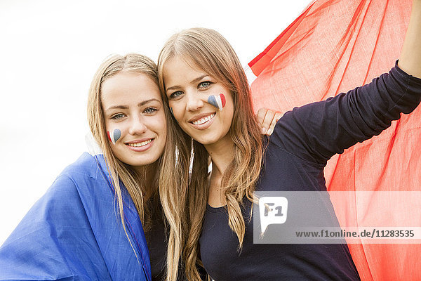 Zwei junge Frauen halten die französische Flagge