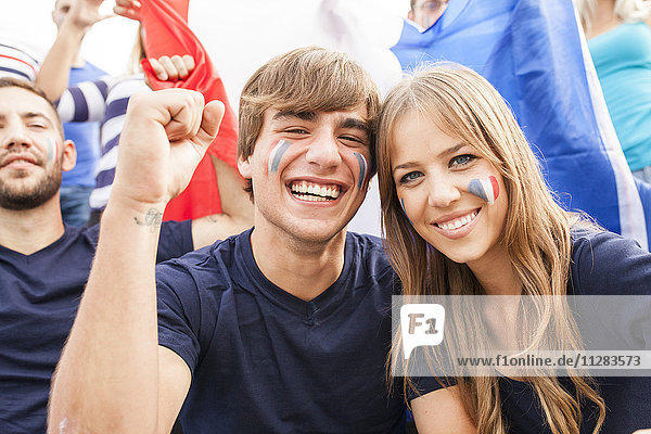 Group of soccer fans celebrating with French flag