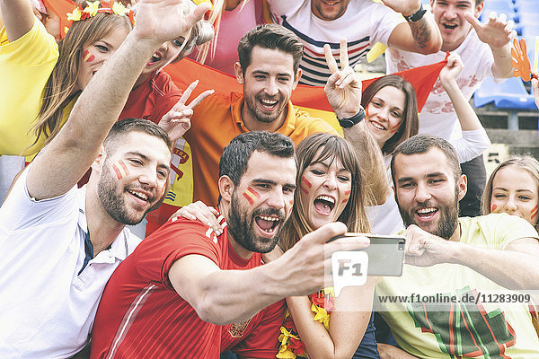 Group of soccer fans taking a selfie in stadium