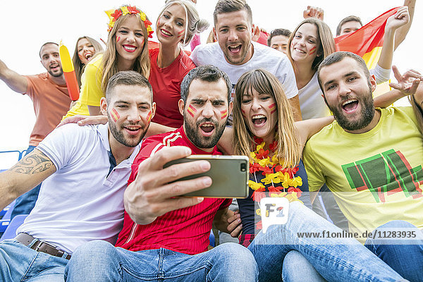 Group of soccer fans taking a selfie in stadium