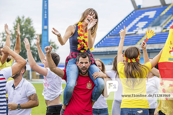 Group of Spanish soccer fans celebrating in stadium