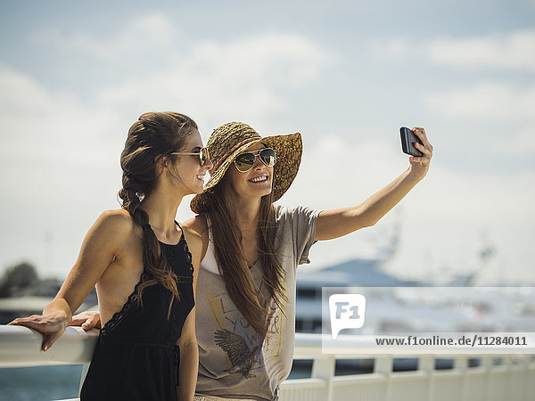 Kaukasische Frauen  die für ein Handy-Selfie posieren