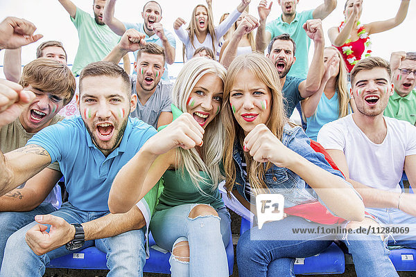 Gruppe von Fußballfans im Stadion, die jubeln und schreien