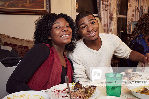 Smiling Black brother and sister at dinner table