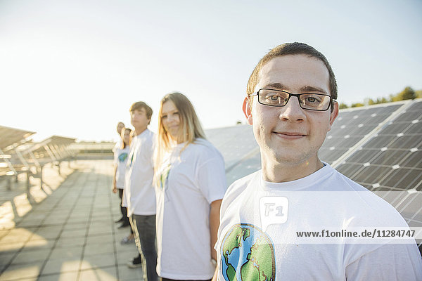 Eine Gruppe von jugendlichen Umweltschützern vor einem Solarpanel