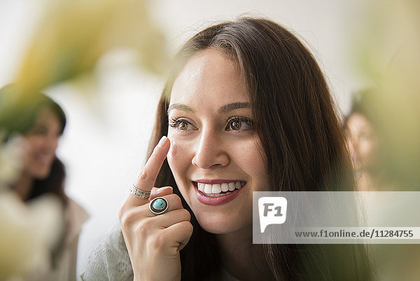Lächelnde Frau trägt Feuchtigkeitscreme auf das Gesicht auf