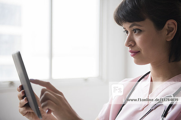 Hispanische Krankenschwester mit digitalem Tablet
