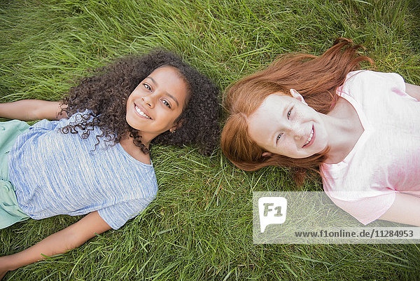 Portrait of smiling girls laying in grass