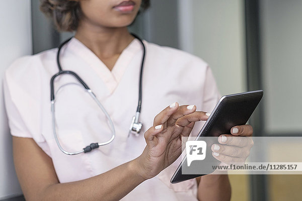 Gemischtrassige Krankenschwester mit digitaler Tafel