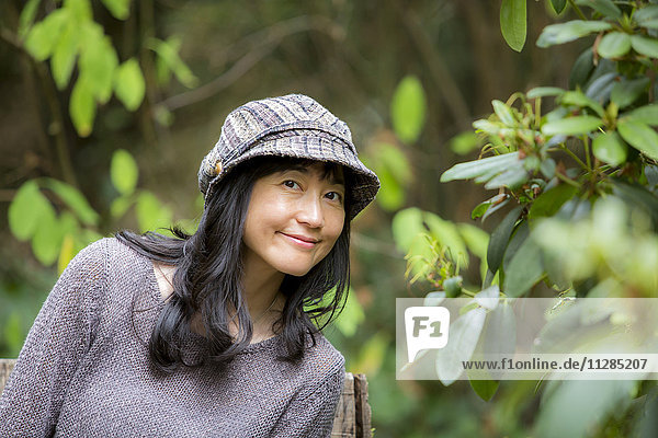 Porträt einer lächelnden japanischen Frau im Wald
