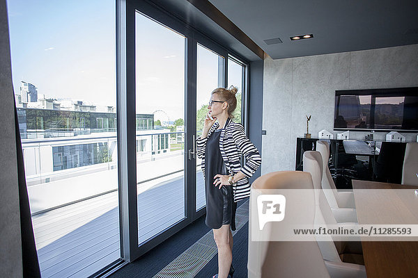 Businesswoman in office looking through window