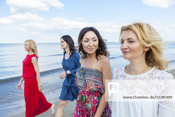 Group of women take a walk along the beach