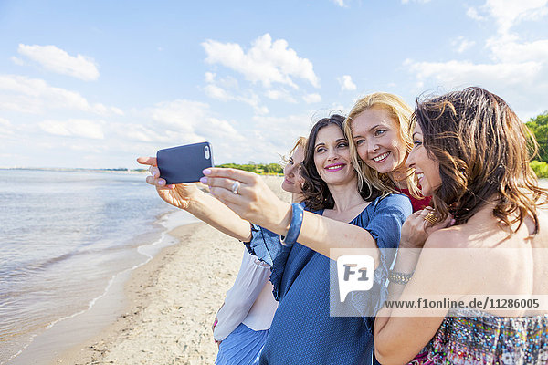 Women on beach taking a selfie