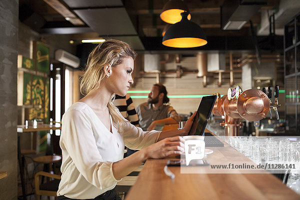 Woman in coffee shop using digital tablet
